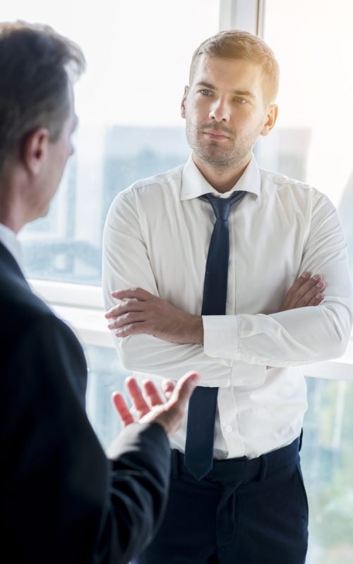 homem-negocios-tendo-conversa-com-seu-socio-masculino-em-escritorio